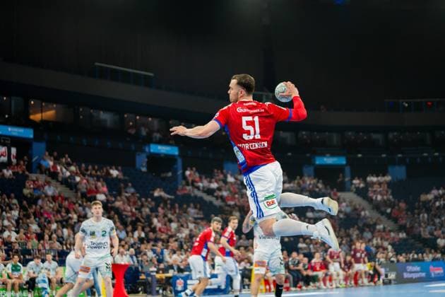 HSV player Casper Ulrich Mortensen jumps to shoot and holds the ball in his right hand In the background you can see players from both teams and the crowd at Barclays Arena Casper Ulrich Mortensen 6 HSV Hamburg jumping to shoot Copyright: xPhilippHeistx