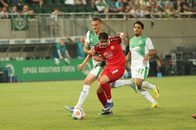 Philipp Ziereis 4 SpVgg Greuther Fürth fights for the ball against a player from Rot Weiss Essen 9 while Sayfallah Ltaief 47 SpVgg Greuther Fürth watches the duel The scene takes place at the Ronhof Sports Park in front of the home crowd Philipp Ziereis 4 SpVgg Greuther Fürth in a duel against Rot Weiss Essen Copyright: xspeedshotx xTimoxBluhmki-Schmidtx