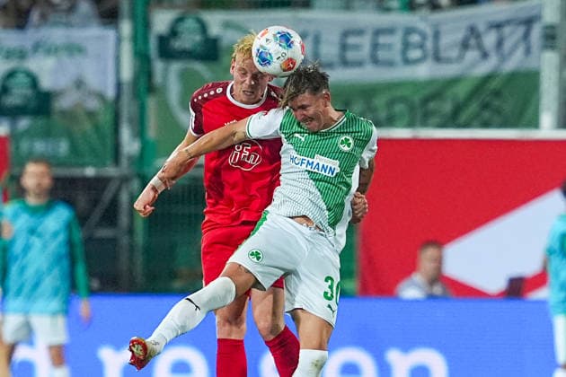 26 05 2026, xydrx, Herren, Fußball, Relegation second leg, 2 Bundesliga, SpVgg Greuther Fürth Rot Weiss Essen, Saison 2025 2026, Sportpark Ronhof Ben Huening Rot Weiss Essen, 15 im Zweikampf gegen Kelsey Aninkorah Meisel Rot Weiss Essen, 30 DFB regulations prohibit any use of photographs as image sequences and or quasi video Copyright: HMBxMedia YannisxDreimann