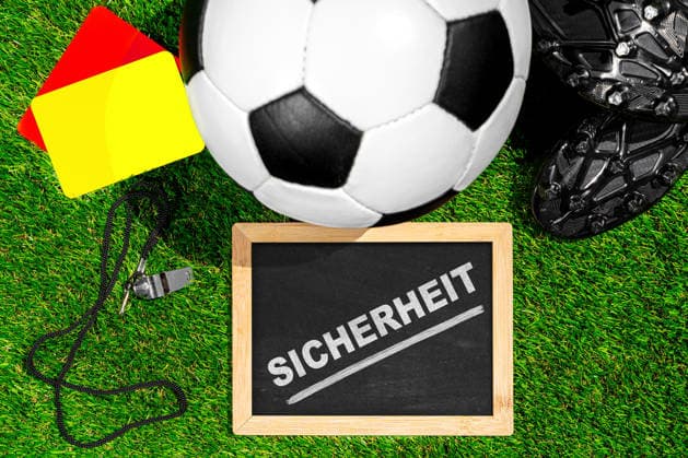 FOTOMONTAGE, Fußballschuhe, Ball und Schiedsrichterausrüstung symbolisieren Sicherheitskonzepte bei der WM 2026 und verdeutlichen Maßnahmen zum Schutz von Spielern, Fans und Veranstaltungen.