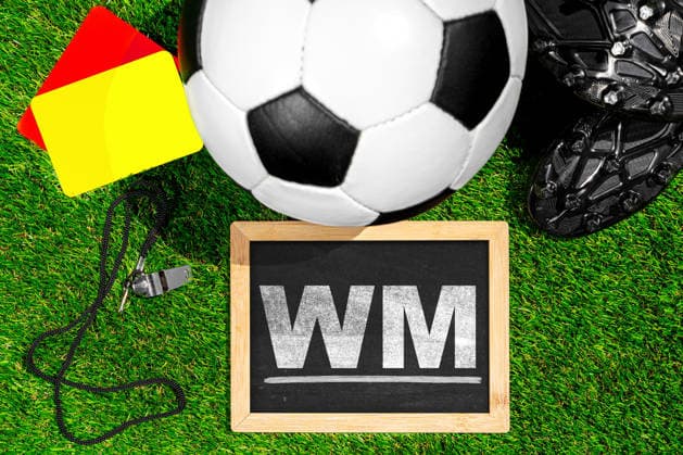 FOTOMONTAGE, Symbolfoto Fußball-WM 2026 - Fußball-Weltmeisterschaft - Fußball auf Rasen neben einer Kreidetafel mit dem Schriftzug WM.