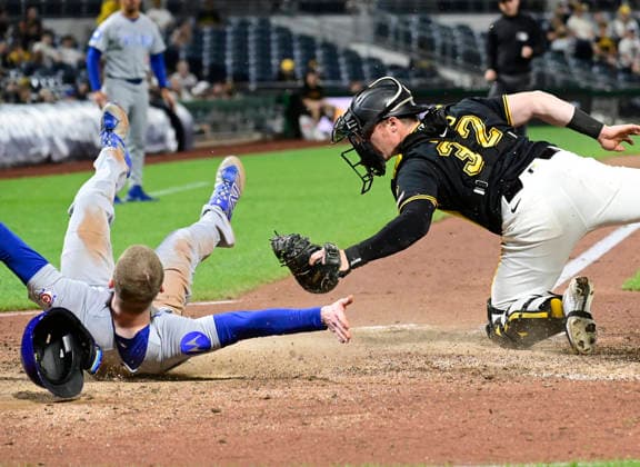 Chicago Cubs center fielder Pete Crow-Armstrong (4) rolls away from Pittsburgh Pirates catcher Henry Davis (32) after sliding into home, as the Chicago Cubs wins the challenge overturning the original out call in the ninth inning of the Cubs 7-2 win at PNC Park on Thursday, May 28, 2026 in Pittsburgh.  PIT2026052829 ArchiexCarpenter