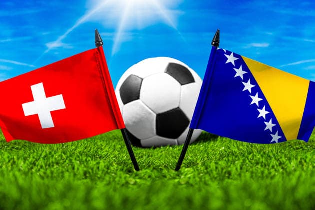 FOTOMONTAGE, Fußball-Weltmeisterschaft 2026: Nationalflaggen von Schweiz und Bosnien Herzegowina mit Fußball auf Rasen. Symbolbild zum WM-Gruppenspiel am 18 Juni bei der FIFA Fussball-Weltmeisterschaft 2026