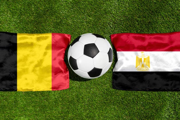 FOTOMONTAGE, Fußball-Weltmeisterschaft 2026: Nationalflaggen von Belgien und Ägypten mit Fußball auf Rasen. Symbolbild zum WM-Gruppenspiel am 15 Juni bei der FIFA Fussball-Weltmeisterschaft 2026
