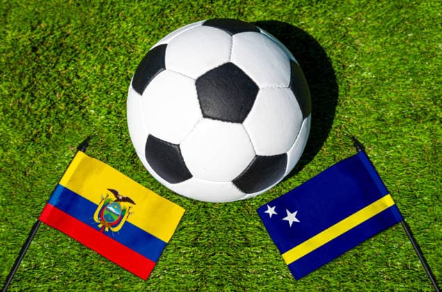 FOTOMONTAGE, Fußball-Weltmeisterschaft 2026: Nationalflaggen von Ecuador und Curacao mit Fußball auf Rasen. Symbolbild zum WM-Gruppenspiel am 21 Juni bei der FIFA Fussball-Weltmeisterschaft 2026