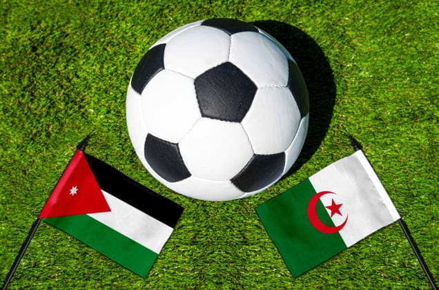 FOTOMONTAGE, Fußball-Weltmeisterschaft 2026: Nationalflaggen von Jordanien und Algerien mit Fußball auf Rasen. Symbolbild zum WM-Gruppenspiel am 23 Juni bei der FIFA Fussball-Weltmeisterschaft 2026