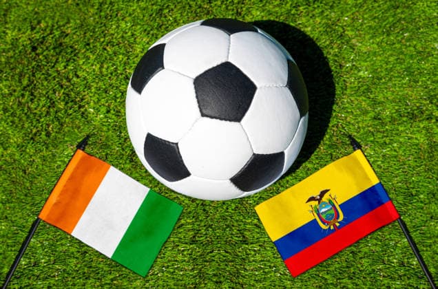 FOTOMONTAGE, Fußball-Weltmeisterschaft 2026: Nationalflaggen von Elfenbeinküste und Equador mit Fußball auf Rasen. Symbolbild zum WM-Gruppenspiel am 15 Juni bei der FIFA Fussball-Weltmeisterschaft 2026