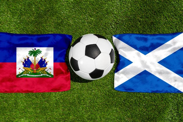 FOTOMONTAGE, Fußball-Weltmeisterschaft 2026: Nationalflaggen von Haiti und Schottland mit Fußball auf Rasen. Symbolbild zum WM-Gruppenspiel am 14 Juni bei der FIFA Fussball-Weltmeisterschaft 2026
