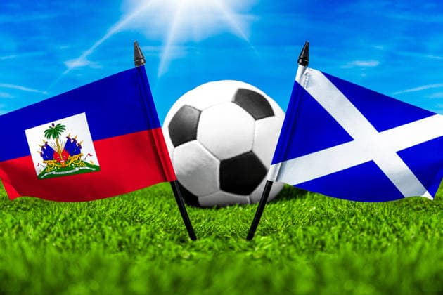 FOTOMONTAGE, Fußball-Weltmeisterschaft 2026: Nationalflaggen von Haiti und Schottland mit Fußball auf Rasen. Symbolbild zum WM-Gruppenspiel am 14 Juni bei der FIFA Fussball-Weltmeisterschaft 2026