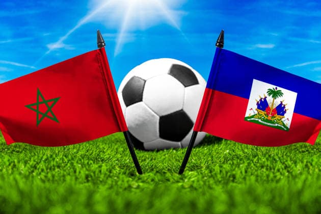 FOTOMONTAGE, Fußball-Weltmeisterschaft 2026: Nationalflaggen von Marokko und Haiti mit Fußball auf Rasen. Symbolbild zum WM-Gruppenspiel am 25 Juni bei der FIFA Fussball-Weltmeisterschaft 2026