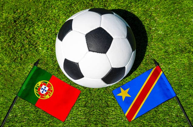 FOTOMONTAGE, Fußball-Weltmeisterschaft 2026: Nationalflaggen von Portugal und Kongo mit Fußball auf Rasen. Symbolbild zum WM-Gruppenspiel am 17 Juni bei der FIFA Fussball-Weltmeisterschaft 2026