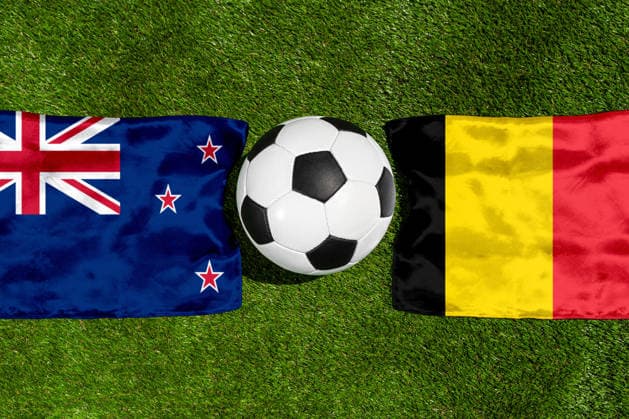 FOTOMONTAGE, Fußball-Weltmeisterschaft 2026: Nationalflaggen von Neuseeland und Belgien mit Fußball auf Rasen. Symbolbild zum WM-Gruppenspiel am 27 Juni bei der FIFA Fussball-Weltmeisterschaft 2026