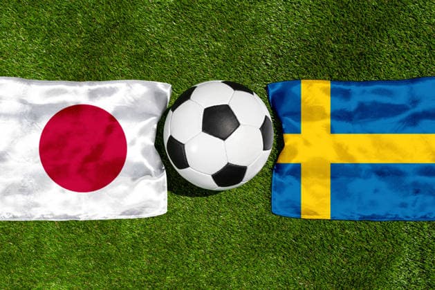 FOTOMONTAGE, Fußball-Weltmeisterschaft 2026: Nationalflaggen von Japan und Schweden mit Fußball auf Rasen. Symbolbild zum WM-Gruppenspiel am 26 Juni bei der FIFA Fussball-Weltmeisterschaft 2026