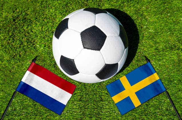 FOTOMONTAGE, Fußball-Weltmeisterschaft 2026: Nationalflaggen von Niederlande und Schweden mit Fußball auf Rasen. Symbolbild zum WM-Gruppenspiel am 20 Juni bei der FIFA Fussball-Weltmeisterschaft 2026