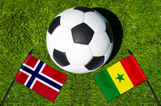 FOTOMONTAGE, Fußball-Weltmeisterschaft 2026: Nationalflaggen von Norwegen und Senegal mit Fußball auf Rasen. Symbolbild zum WM-Gruppenspiel am 23 Juni bei der FIFA Fussball-Weltmeisterschaft 2026