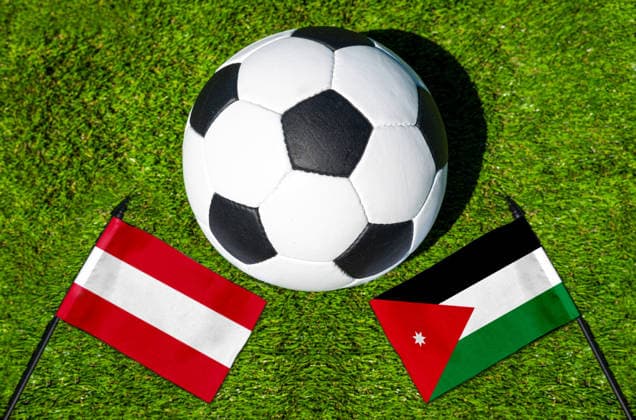 FOTOMONTAGE, Fußball-Weltmeisterschaft 2026: Nationalflaggen von Österreich und Jordanien mit Fußball auf Rasen. Symbolbild zum WM-Gruppenspiel am 17 Juni bei der FIFA Fussball-Weltmeisterschaft 2026