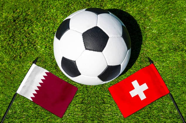 FOTOMONTAGE, Fußball-Weltmeisterschaft 2026: Nationalflaggen von Katar und Schweiz mit Fußball auf Rasen. Symbolbild zum WM-Gruppenspiel am 13 Juni bei der FIFA Fussball-Weltmeisterschaft 2026
