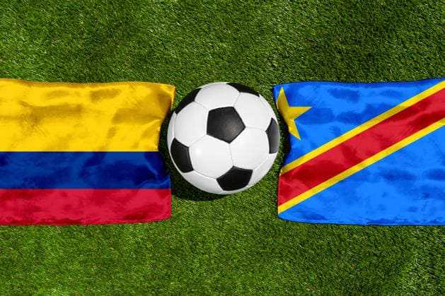 FOTOMONTAGE, Fußball-Weltmeisterschaft 2026: Nationalflaggen von Kolumbien und Kongo mit Fußball auf Rasen. Symbolbild zum WM-Gruppenspiel am 24 Juni bei der FIFA Fussball-Weltmeisterschaft 2026