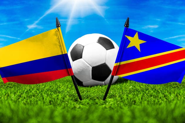 FOTOMONTAGE, Fußball-Weltmeisterschaft 2026: Nationalflaggen von Kolumbien und Kongo mit Fußball auf Rasen. Symbolbild zum WM-Gruppenspiel am 24 Juni bei der FIFA Fussball-Weltmeisterschaft 2026