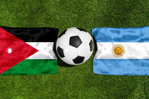 FOTOMONTAGE, Fußball-Weltmeisterschaft 2026: Nationalflaggen von Jordanien und Argentinien mit Fußball auf Rasen. Symbolbild zum WM-Gruppenspiel am 28 Juni bei der FIFA Fussball-Weltmeisterschaft 2026