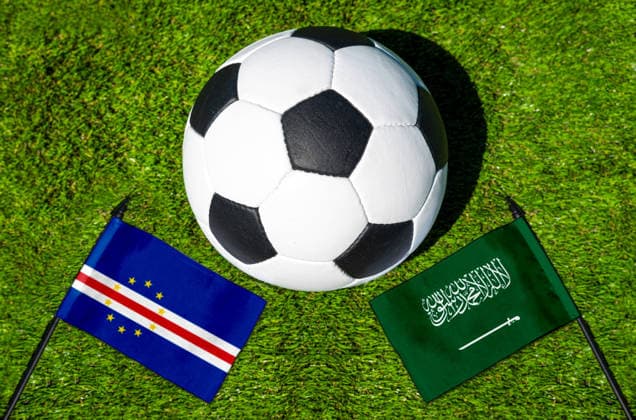 FOTOMONTAGE, Fußball-Weltmeisterschaft 2026: Nationalflaggen von Kap Verde und Saudi-Arabien mit Fußball auf Rasen. Symbolbild zum WM-Gruppenspiel am 27 Juni bei der FIFA Fussball-Weltmeisterschaft 2026