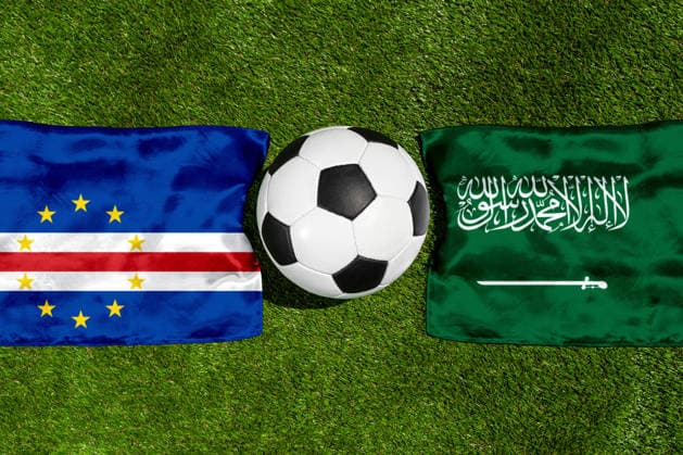 FOTOMONTAGE, Fußball-Weltmeisterschaft 2026: Nationalflaggen von Kap Verde und Saudi-Arabien mit Fußball auf Rasen. Symbolbild zum WM-Gruppenspiel am 27 Juni bei der FIFA Fussball-Weltmeisterschaft 2026