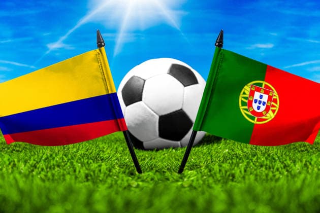 FOTOMONTAGE, Fußball-Weltmeisterschaft 2026: Nationalflaggen von Kolumbien und Portugal mit Fußball auf Rasen. Symbolbild zum WM-Gruppenspiel am 28 Juni bei der FIFA Fussball-Weltmeisterschaft 2026