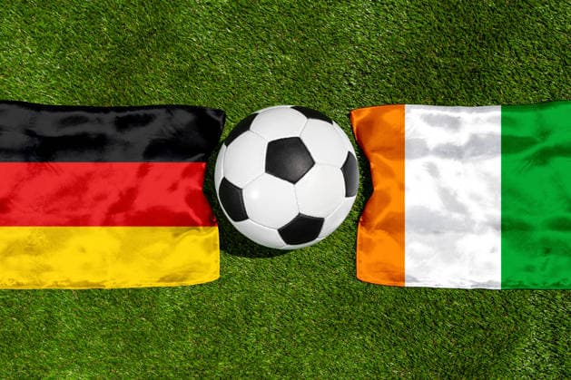 FOTOMONTAGE, Fußball-Weltmeisterschaft 2026: Nationalflaggen von Deutschland und Elfenbeinküste mit Fußball auf Rasen. Symbolbild zum WM-Gruppenspiel am 20 Juni bei der FIFA Fussball-Weltmeisterschaft 2026