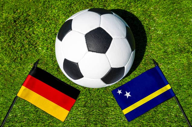 FOTOMONTAGE, Fußball-Weltmeisterschaft 2026: Nationalflaggen von Deutschland und Curacao mit Fußball auf Rasen. Symbolbild zum WM-Gruppenspiel am 14 Juni bei der FIFA Fussball-Weltmeisterschaft 2026