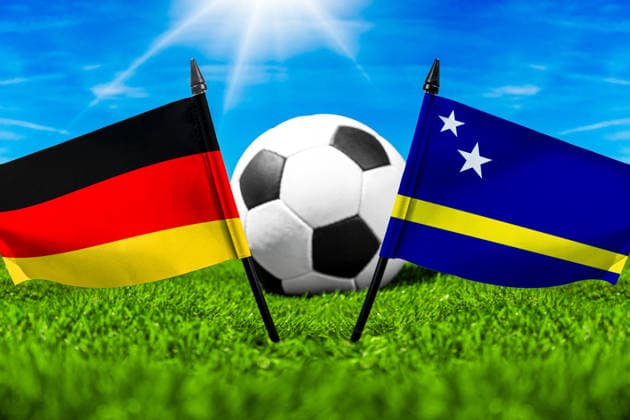 FOTOMONTAGE, Fußball-Weltmeisterschaft 2026: Nationalflaggen von Deutschland und Curacao mit Fußball auf Rasen. Symbolbild zum WM-Gruppenspiel am 14 Juni bei der FIFA Fussball-Weltmeisterschaft 2026