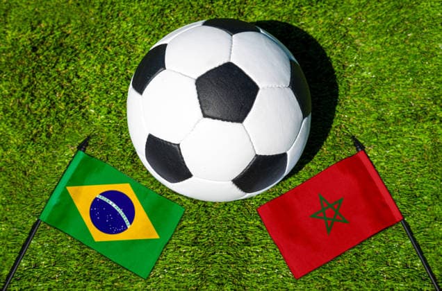 FOTOMONTAGE, Fußball-Weltmeisterschaft 2026: Nationalflaggen von Brasilien und Marokko mit Fußball auf Rasen. Symbolbild zum WM-Gruppenspiel am 14 Juni bei der FIFA Fussball-Weltmeisterschaft 2026
