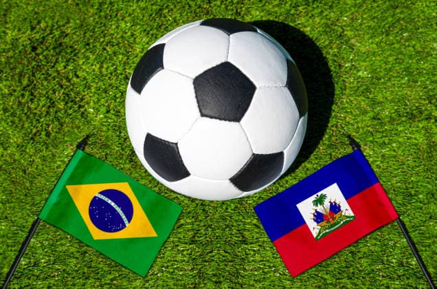 FOTOMONTAGE, Fußball-Weltmeisterschaft 2026: Nationalflaggen von Brasilien und Haiti mit Fußball auf Rasen. Symbolbild zum WM-Gruppenspiel am 20 Juni bei der FIFA Fussball-Weltmeisterschaft 2026