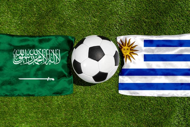 FOTOMONTAGE, Fußball-Weltmeisterschaft 2026: Nationalflaggen von Saudi-Arabien und Uruguay mit Fußball auf Rasen. Symbolbild zum WM-Gruppenspiel am 16 Juni bei der FIFA Fussball-Weltmeisterschaft 2026