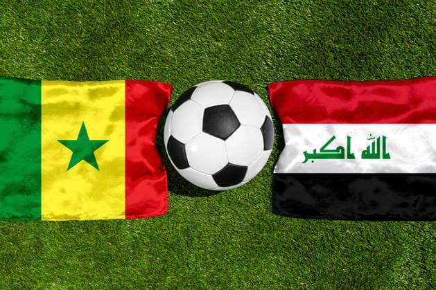 FOTOMONTAGE, Fußball-Weltmeisterschaft 2026: Nationalflaggen von Senegal und Irak mit Fußball auf Rasen. Symbolbild zum WM-Gruppenspiel am 26 Juni bei der FIFA Fussball-Weltmeisterschaft 2026
