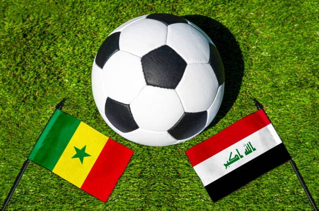 FOTOMONTAGE, Fußball-Weltmeisterschaft 2026: Nationalflaggen von Senegal und Irak mit Fußball auf Rasen. Symbolbild zum WM-Gruppenspiel am 26 Juni bei der FIFA Fussball-Weltmeisterschaft 2026