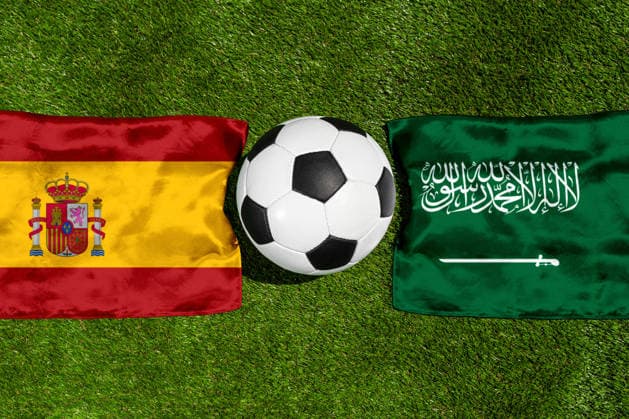 FOTOMONTAGE, Fußball-Weltmeisterschaft 2026: Nationalflaggen von Spanien und Saudi-Arabien mit Fußball auf Rasen. Symbolbild zum WM-Gruppenspiel am 21 Juni bei der FIFA Fussball-Weltmeisterschaft 2026