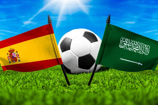 FOTOMONTAGE, Fußball-Weltmeisterschaft 2026: Nationalflaggen von Spanien und Saudi-Arabien mit Fußball auf Rasen. Symbolbild zum WM-Gruppenspiel am 21 Juni bei der FIFA Fussball-Weltmeisterschaft 2026