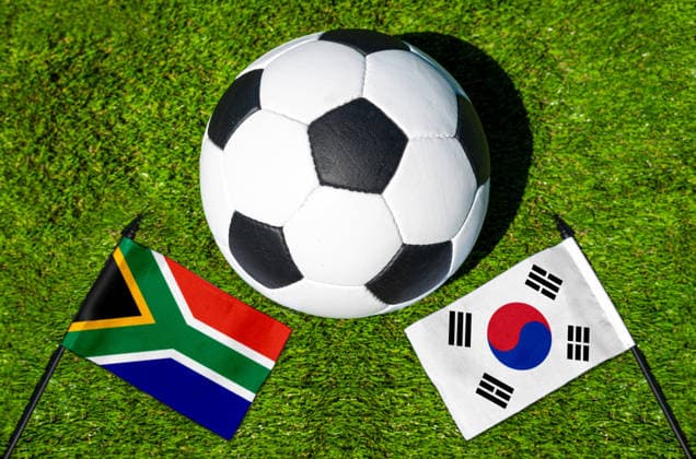 FOTOMONTAGE, Fußball-Weltmeisterschaft 2026: Nationalflaggen von Südafrika und Südkorea mit Fußball auf Rasen. Symbolbild zum WM-Gruppenspiel am 25 Juni bei der FIFA Fussball-Weltmeisterschaft 2026