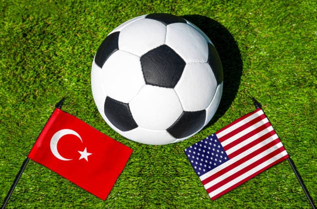 FOTOMONTAGE, Fußball-Weltmeisterschaft 2026: Nationalflaggen von Türkei und USA mit Fußball auf Rasen. Symbolbild zum WM-Gruppenspiel am 26 Juni bei der FIFA Fussball-Weltmeisterschaft 2026