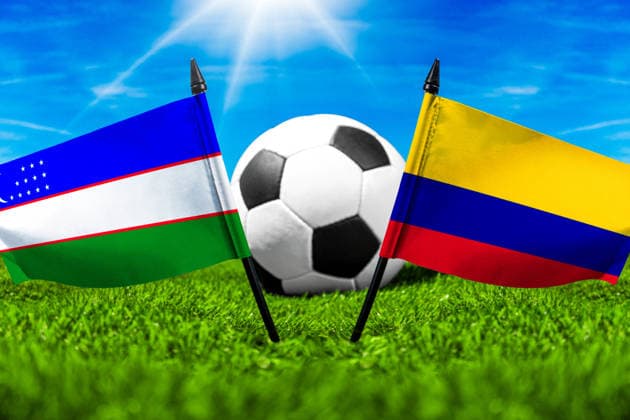 FOTOMONTAGE, Fußball-Weltmeisterschaft 2026: Nationalflaggen von Usbekistan und Kolumbien mit Fußball auf Rasen. Symbolbild zum WM-Gruppenspiel am 18 Juni bei der FIFA Fussball-Weltmeisterschaft 2026