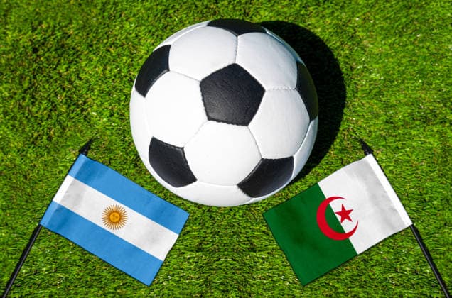 FOTOMONTAGE, Fußball-Weltmeisterschaft 2026: Nationalflaggen von Argentinien und Algerien mit Fußball auf Rasen. Symbolbild zum WM-Gruppenspiel am 17 Juni bei der FIFA Fussball-Weltmeisterschaft 2026