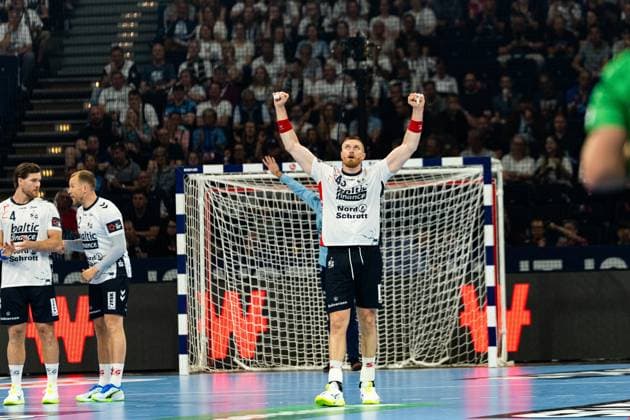 Blaz Blagotinsek 43 SG Flensburg Handewitt raises both arms in the air and cheers exuberantly in front of the goal Johannes Golla 3 SG Flensburg Handewitt and another SG Flensburg Handewitt player stand in the background MT Melsungen vs SG Flensburg Handewitt - EHF Finals Hamburg 2026 Copyright: xPhilippHeistx