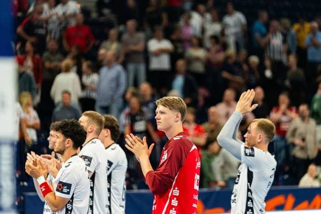 Moritz Frederik Detlefsen 18 SG Flensburg Handewitt stands in a dark red jersey next to SG Flensburg Handewitt players and applauds in the direction of the spectators A well-filled grandstand can be seen in the background MT Melsungen vs SG Flensburg Handewitt - EHF Finals Hamburg 2026 Copyright: xPhilippHeistx