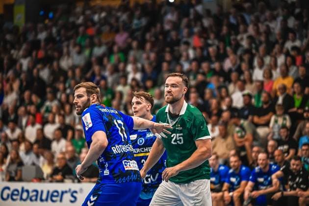 A player from Frisch Auf Göppingen 25 asserts himself in a duel against a player from TVB Stuttgart Another person from Frisch Auf Göppingen can be seen in the background, while the hall is filled with spectators Duel between TVB Stuttgart and Frisch Auf Göppingen 25 Copyright: xspeedshotx xDorianfrickx