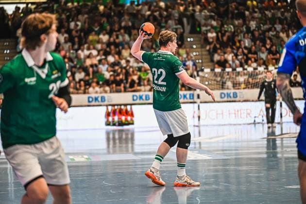 Erik Persson 22 Frisch Auf Göppingen takes a shot with the ball in his raised hand The TVB Stuttgart goalkeeper and a TVB Stuttgart defender can be seen in the background Erik Persson 22 Frisch Auf Göppingen taking a shot Copyright: xspeedshotx xDorianfrickx