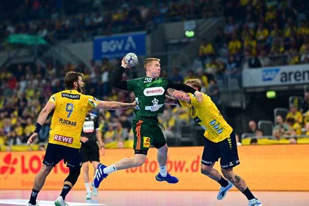 Bendix Dietzsch 20 TSV Hannover Burgdorf jumps with the ball to shoot and is pressured by two Rhein Neckar Löwen players Left Steven Plucnar Jacobsen 9 Rhein Neckar Löwen tries to stop the attack Bendix Dietzsch 20 TSV Hannover Burgdorf in a jump shot against Rhein Neckar Löwen Copyright: xMichaelxGelhardtx