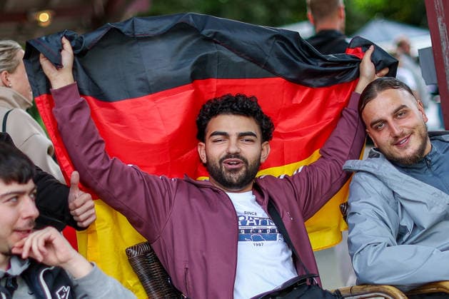 14 06 2026, Cologne, Public Viewing for the FIFA World Cup 2026, international match World Cup Germany Curacao, fans with German flag in the beer garden look forward to the game and cheer about the goal the victory of the German national team North Rhine-Westphalia Germany