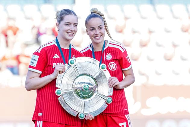 German national team players Alara Sehitler (No. 14, Bayern) and Giulia Gwinn (No. 7, FC Bayern) celebrate their victory in the 2025–2026 Google Pixel Women’s Bundesliga with the championship trophy on May 9, 2026, at the FC Bayern Campus in Munich, Bavaria, Germany.