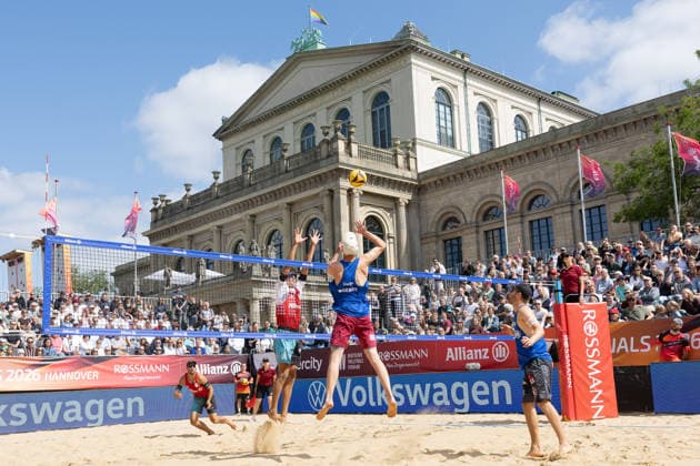 2026 German Beach Volleyball Championships: Manuel Harms of Kiel attacks against the block set by Valentin Schneckenburger of Munich. German Beach Volleyball Championships on July 24, 2026, in Hanover. Men’s quarterfinal match between 1 Beachclub Kiel and Beachvolley United Munich, Hanover, Lower Saxony, Germany, Opernplatz