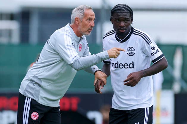 Adi Hütter, coach of Eintracht Frankfurt, and Dina Ebimbe, a junior player for Eintracht Frankfurt, chat during the friendly match between Trabzonspor and Eintracht Frankfurt at the SAK Sportanlage Nonntal in Salzburg on July 26, 2026, Austria. Photo by Marco Steinbrenner, DeFodi Images. Eintracht Frankfurt coach Adi Hütter and Eintracht Frankfurt youth player Dina Ebimbe talk together during the friendly match between Trabzonspor and Eintracht Frankfurt at SAK Sportanlage Nonntal on July 26, 2026 in Salzburg, Austria. Photo by Marco Steinbrenner, DeFodi Images